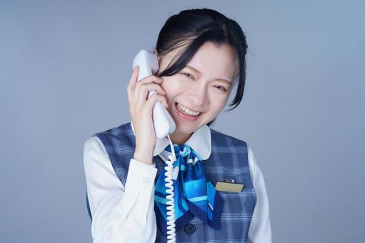 電話で笑顔の青いリボンの制服の女性 女性,電話,笑顔の写真素材