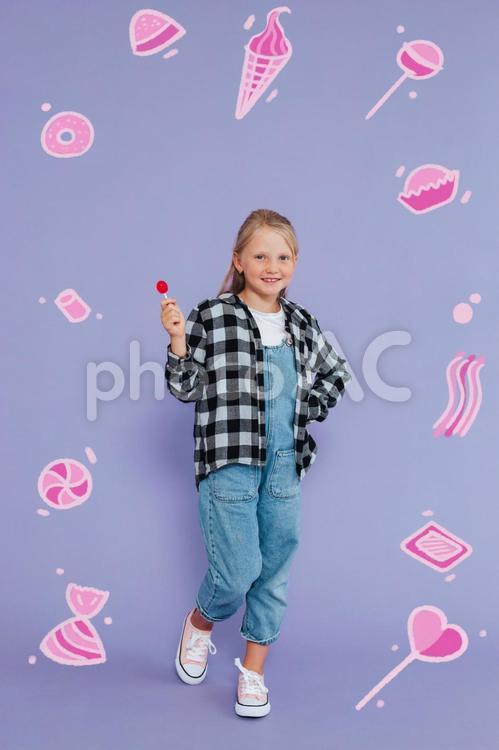 スイーツイラストに囲まれた笑顔の女の子 女の子,キャンディー,持つの写真素材