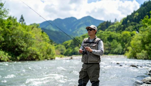 サングラスをして渓流釣りをする男性 サングラスをして渓流釣りをする男性の写真