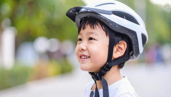 自転車用ヘルメットをかぶる男の子 自転車用ヘルメットをかぶる男の子の写真