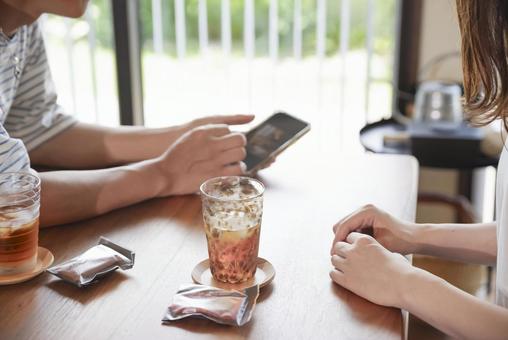 スマホを見ながら笑顔で会話する男女 会話,談笑,笑顔の写真素材