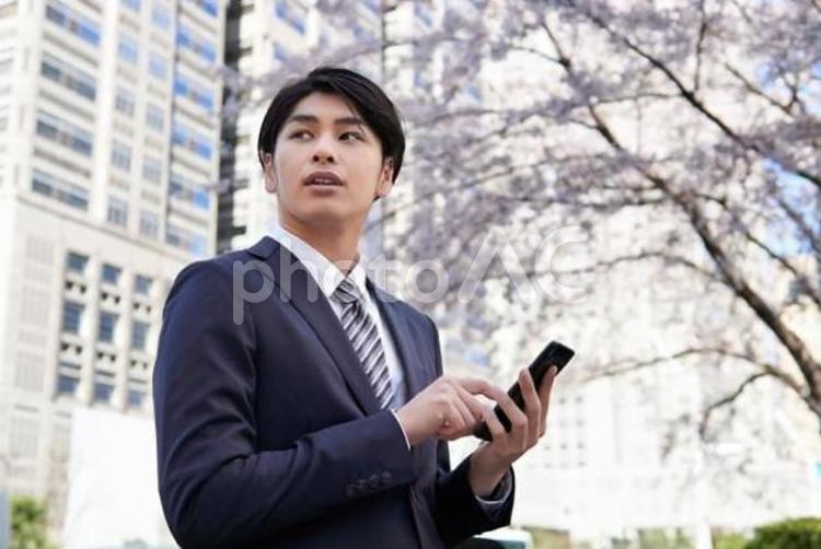 スマートフォンを操作するビジネスマン ビジネスマン,男性,新入社員の写真素材