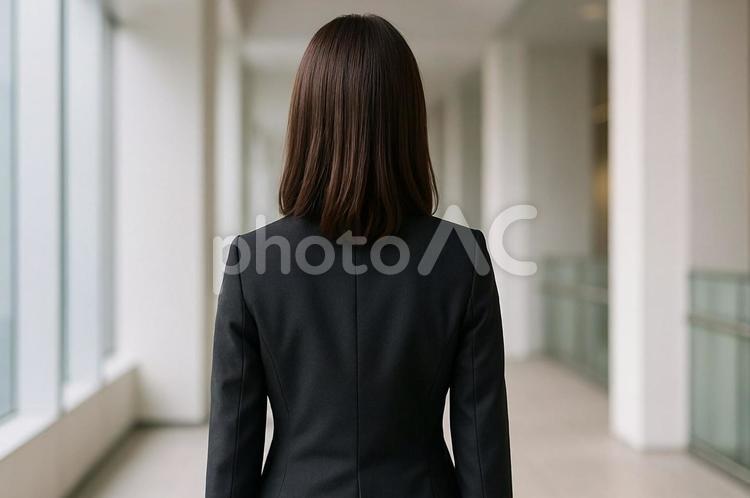 オフィスでビジネススーツ姿の女性の後ろ姿 ビジネスウーマン,スーツ,後ろ姿の写真素材