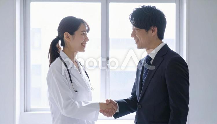 握手するビジネスパーソンと医者 握手,ビジネス,笑顔の写真素材