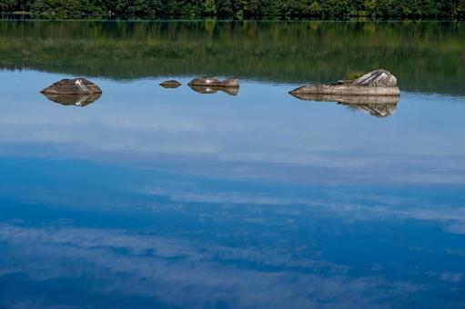 静寂な大沼の湖面に浮かぶ岩と森の映り込み 静寂な大沼の湖面に浮かぶ岩と森の映り込み 大沼,湖,湖面の写真素材