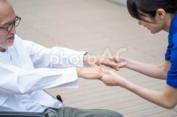 車いすから立ち上がる介助をするスタッフ 女性,介護,介護士の写真素材