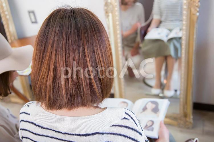 ヘアカタログを見る女性と美容師 ヘアカタログ,雑誌,見るの写真素材