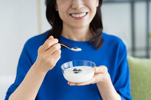 ヨーグルトを食べるミドルの女性 ヨーグルトを食べるミドルの女性の写真