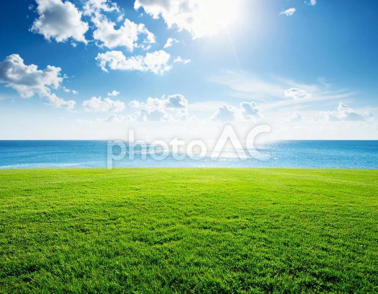 雲のある青空に太陽の下、海と草原 自然,芝生,草原の写真素材