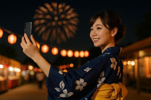 花火を背景に浴衣女性が自撮り 花火を背景に浴衣女性が自撮りの写真