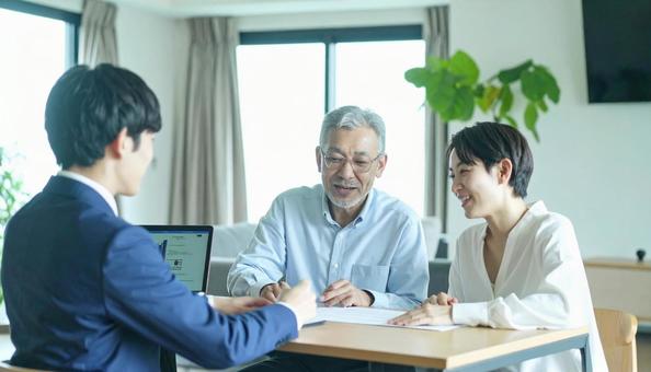 男性営業マンの説明を聞く親子の写真