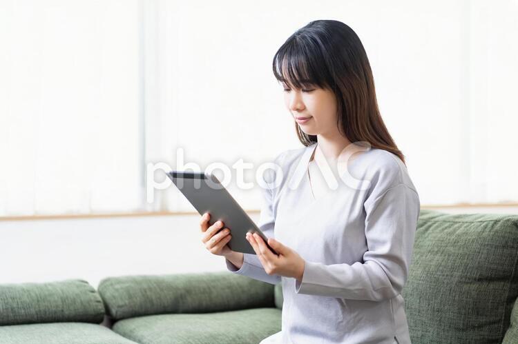 タブレット端末を使う若い女性 タブレット端末を使う若い女性 女性,タブレット,snsの写真素材