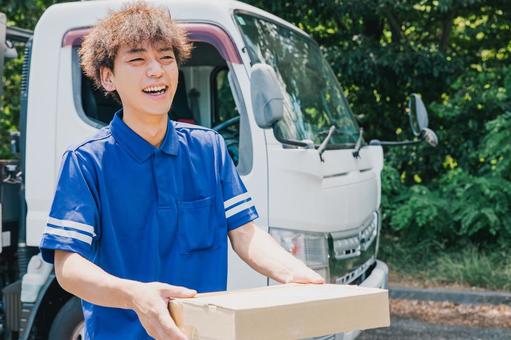 笑顔でお客様に商品を届ける配送業者 笑顔でお客様に商品を届ける配送業者 トラック,トラック男性,運搬の写真素材