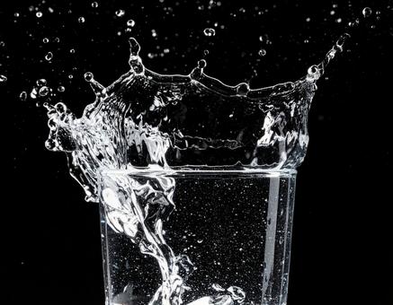 透明なグラスから勢いよくあふれる水2 透明なグラスから勢いよくあふれる水2の写真