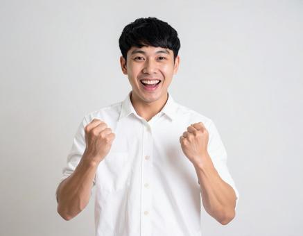 ガッツポーズで喜ぶ若い男性 ガッツポーズで喜ぶ若い男性の写真