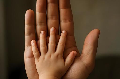 重なる親子の手の写真