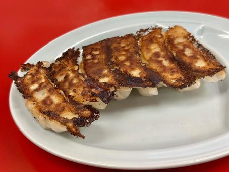 香ばしく焼き上げた熱々の餃子 香ばしく焼き上げた熱々の餃子の写真