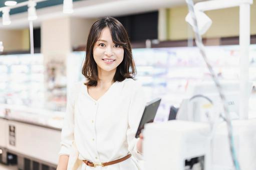 スーパーでスマホ決済を使う若い女性 スーパーでスマホ決済を使う若い女性 家計,決済端末,女性の写真素材