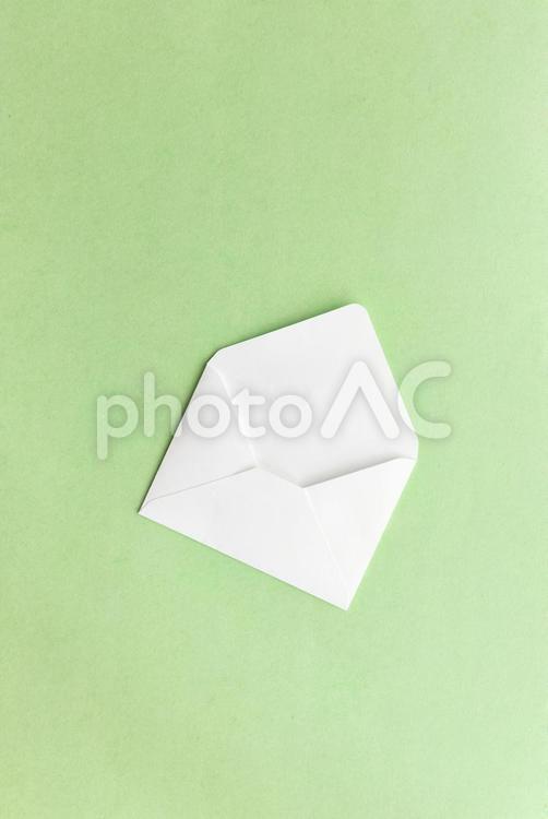 白い洋形封筒（黄緑色背景） モックアップ,物撮り,封筒の写真素材