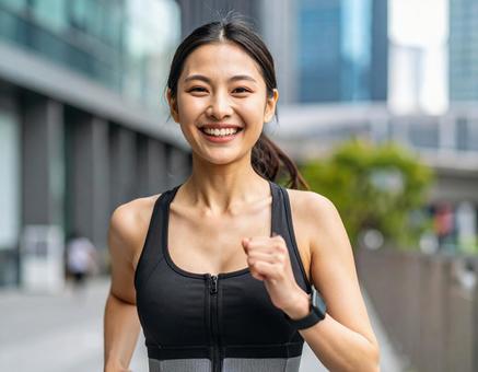 街中でジョギングをする若い女性の写真
