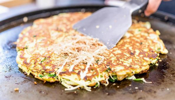 お好み焼きを鉄板で焼く お好み焼きを鉄板で焼くの写真