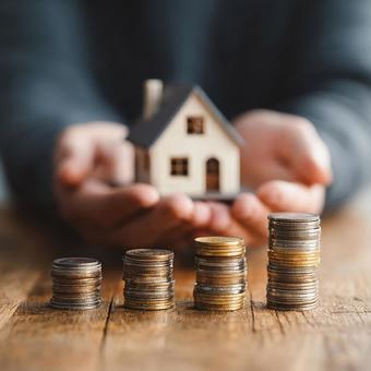 硬貨と家の模型で表現された投資の成長 硬貨と家の模型で表現された投資の成長の写真