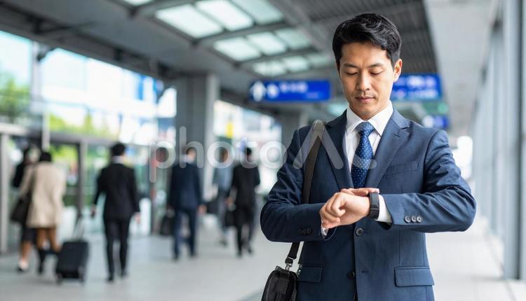 腕時計を見るビジネスマン　駅構内 ビジネスマン,男性,腕時計の写真素材