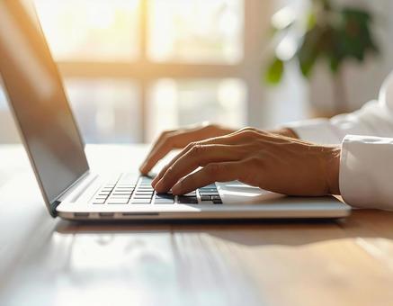 パソコンのキーボードを打つ手の写真