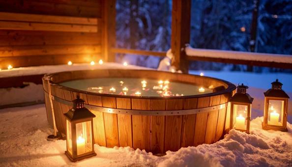 ランタンの明かりが灯る夜の雪山の露天風呂の写真