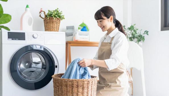 洗濯機からタオルを取り出す若い日本人女性 洗濯機からタオルを取り出す若い日本人女性の写真
