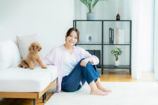 部屋でペットとくつろぐ若い女性 部屋でペットとくつろぐ若い女性 ペット,女性,犬の写真素材