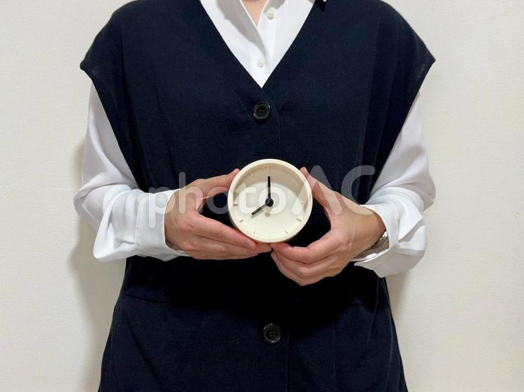 8時・20時をさす時計を持った女性 時計,時間,女性の写真素材