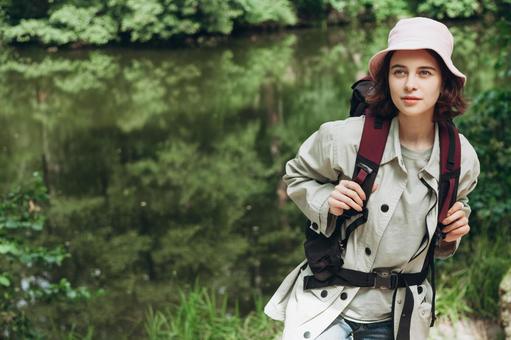 森を歩く女性キャンパーの写真