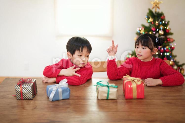 机の上に置かれたプレゼントを見る子供たち 男女,クリスマス,プレゼントの写真素材