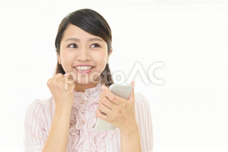 スマートフォンを持つ笑顔の女性 女性,スマートフォン,女の写真素材