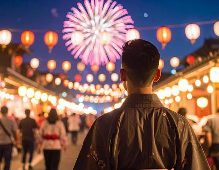 浴衣姿の男性が打ち上げ花火を見ているの写真