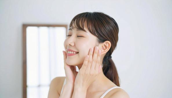 ほほをさわり満足して目をつむる若い女性 ほほをさわり満足して目をつむる若い女性の写真