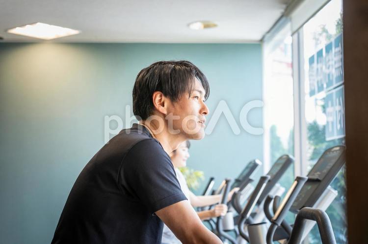 エアロバイクで運動する男性 エアロバイク,有酸素運動,スポーツジムの写真素材