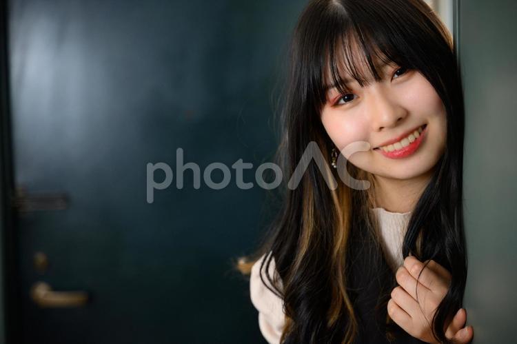 玄関からこちらを見る10代の女性 女性,女子,女の写真素材