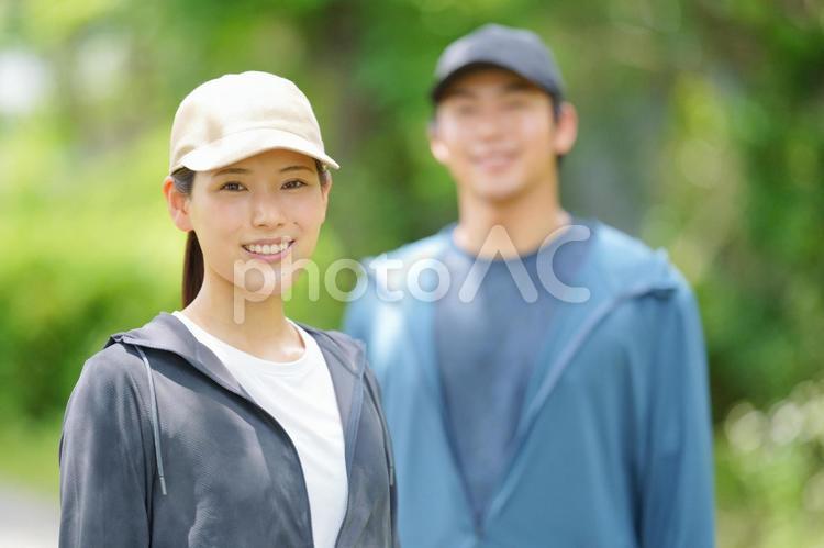 キャップを被ったカメラ目線の女性と男性 男性,女性,人物の写真素材