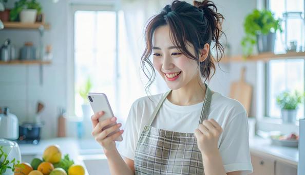スマホでポイ活する笑顔の女性 スマホでポイ活する笑顔の女性の写真