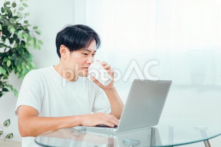 ノートパソコンを使う男性 男性,笑顔,自宅の写真素材