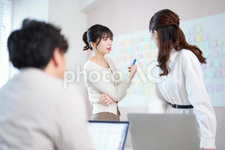 付箋を差し話す女性 男女,ノートパソコン,話すの写真素材