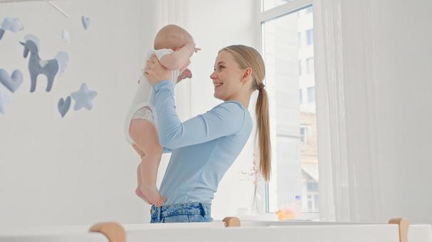 笑顔で赤ちゃんを抱く若い女性 笑顔で赤ちゃんを抱く若い女性 親子,抱っこ,赤ちゃんの写真素材