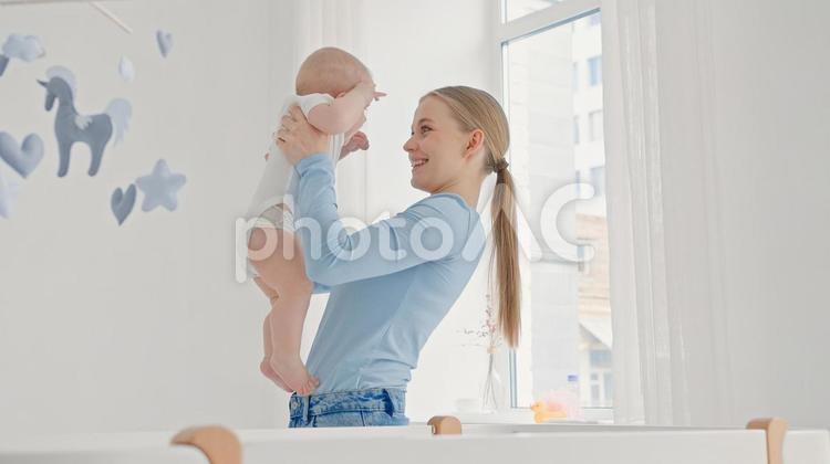 笑顔で赤ちゃんを抱く若い女性 親子,抱っこ,赤ちゃんの写真素材