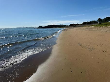 海辺の砂浜に打ち寄せる波と青い空 海辺の砂浜に打ち寄せる波と青い空の写真