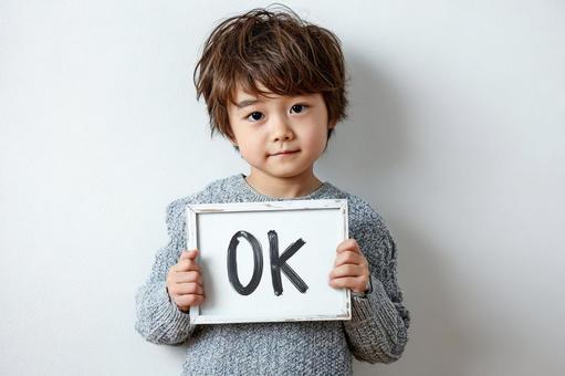 OKと書いたボードを見せる子供 OKと書いたボードを見せる子供の写真