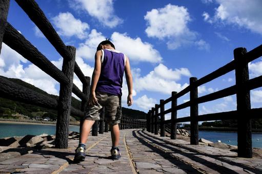 <素材>海辺の遊歩道を散歩する男の子 <素材>海辺の遊歩道を散歩する男の子 子供,海,空の写真素材