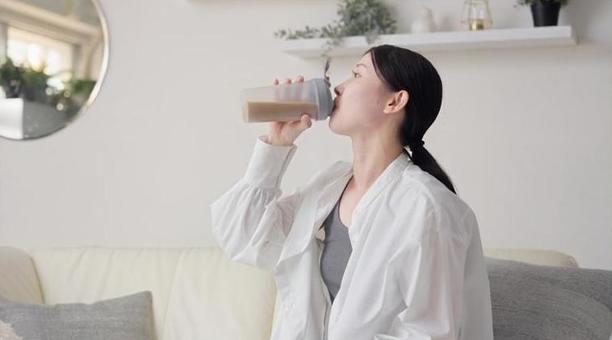 リビングでプロテインを飲むアジア人女性 プロテイン,飲む,女性の写真素材