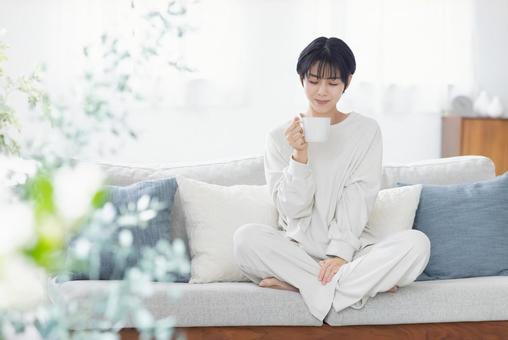 ソファーで目覚めのコーヒーを飲む女性 ソファーで目覚めのコーヒーを飲む女性 女性,日本人,コーヒーの写真素材